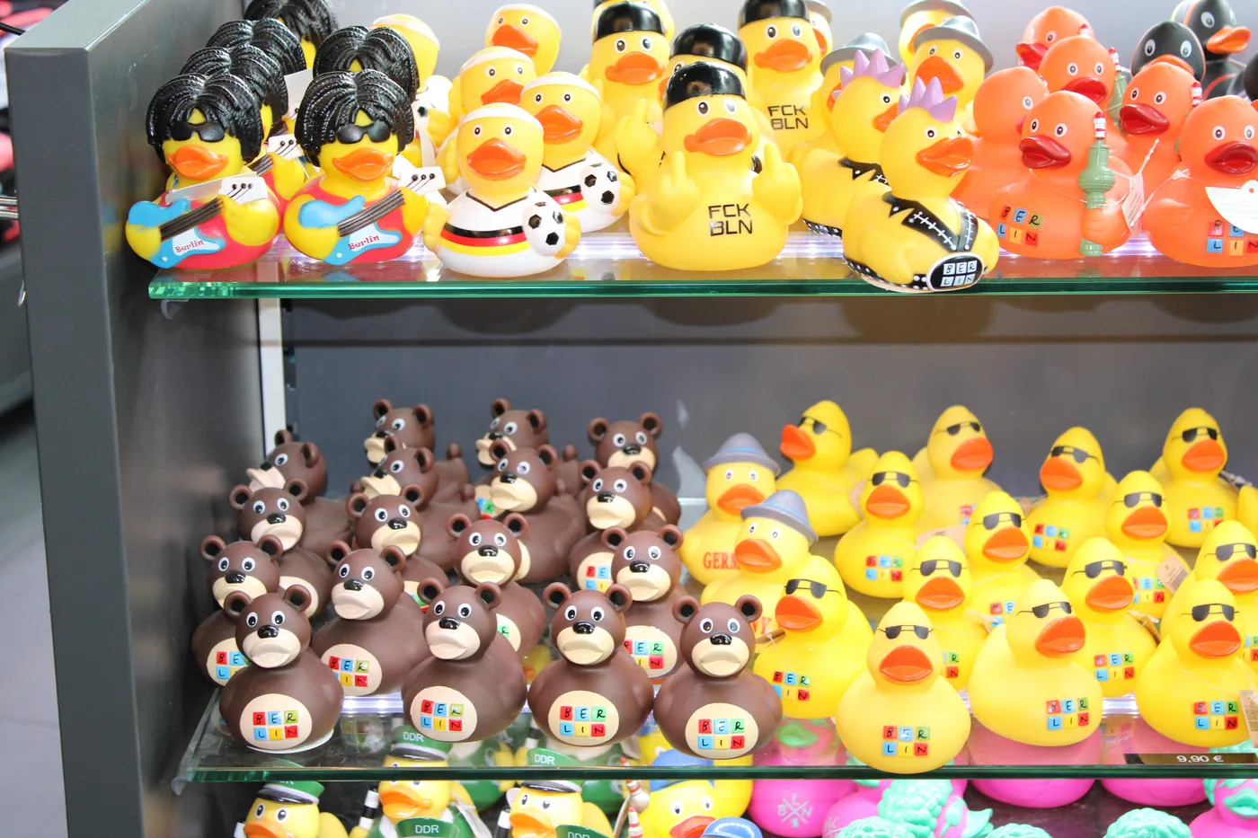 Bunte Gummienten in Reihen auf einem Regalbrett